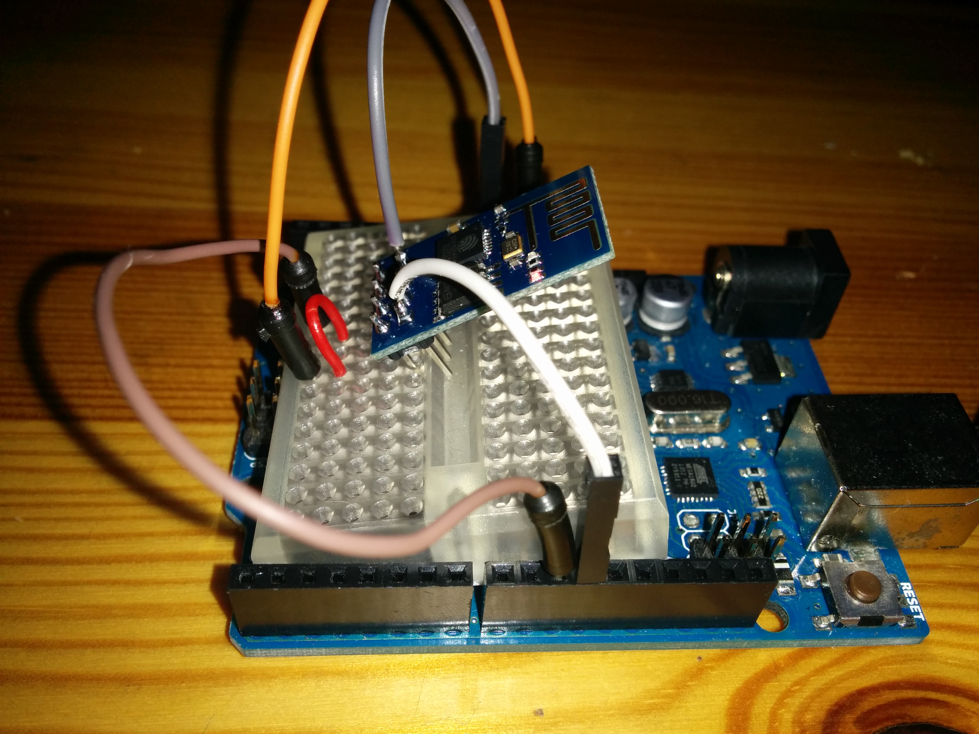 Zum Aufbau:
An die Modul-Pins GND (grauer Draht) und RXD (weiß) habe ich jeweils kurze Verbindungsdrähte angelötet. Das Modul selbst ist leicht schräg in ein Steckboard gesteckt, so dass die beiden oben erwähnten Pins keine Verbindung haben. Dafür kommt man über die interne Verdahtung des Steckboards gut an die Pins VCC (gelb/orange) undTXD (braun). Der PD Pin ist direkt mit einer Drahtbrücke mit VCC verbunden. RXD ist mit dem Arduino Pin 10 und TXD mit Pin11verbunden. VCC wird mit dem 3,3 V-Power-Pin verbunden und GND mit GND.